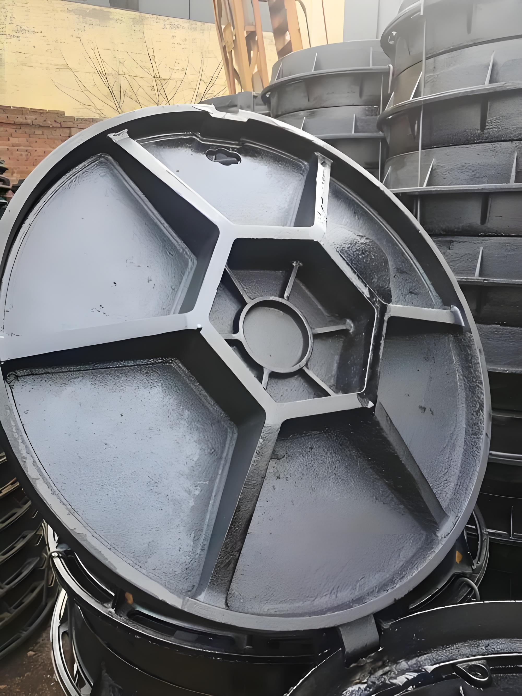 Ductile iron manhole cover underside reinforcement